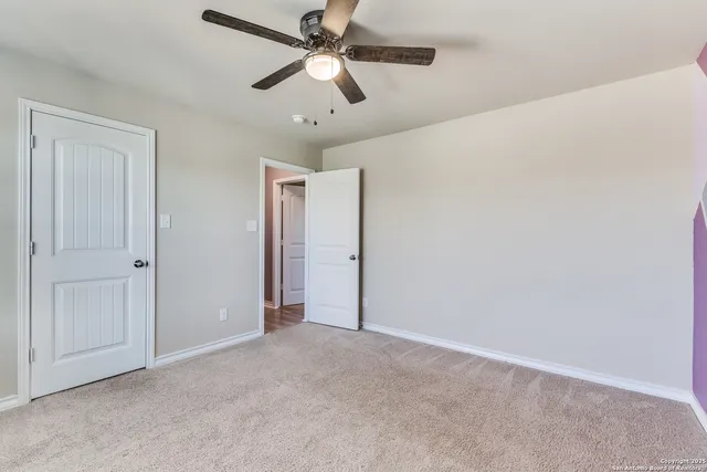 an empty room with closet and a chandelier fan