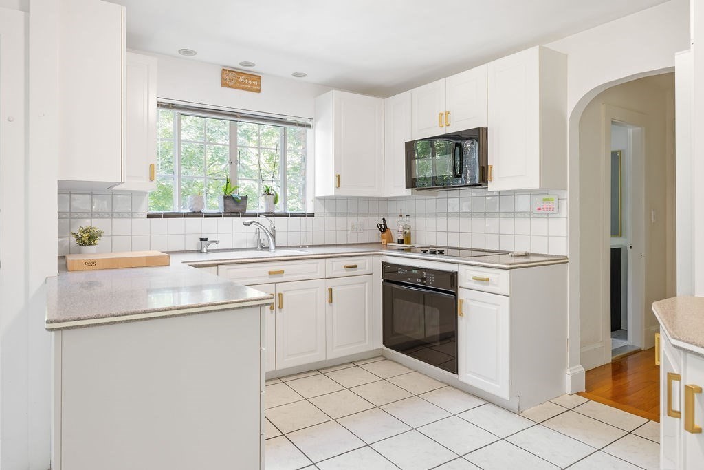 1069 West Roxbury Parkway Brookline, MA 02467 - Photo 8 of 27 a kitchen with a sink stove and cabinets