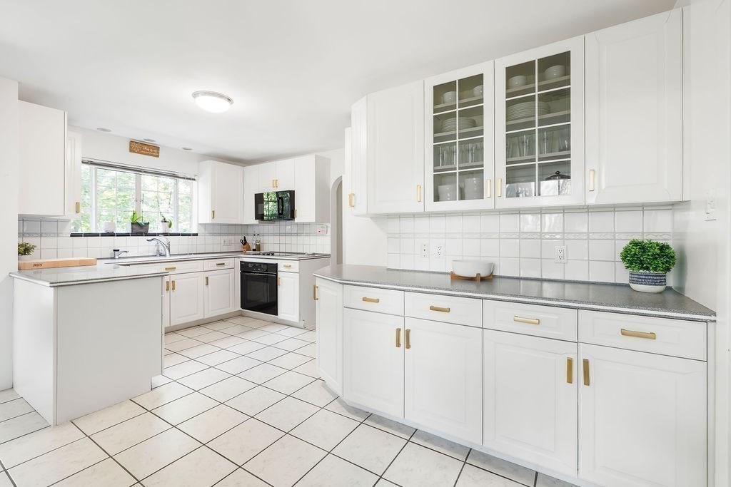 1069 West Roxbury Parkway Brookline, MA 02467 - Photo 9 of 27 a kitchen with granite countertop white cabinets and white appliances
