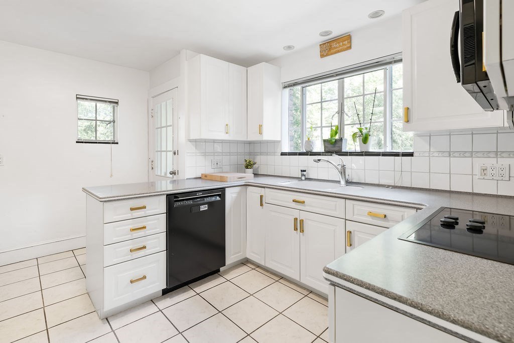 1069 West Roxbury Parkway Brookline, MA 02467 - Photo 10 of 27 a kitchen with cabinets appliances a sink and a window