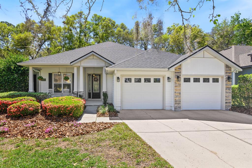 8467 Southwest 80th Place Gainesville, FL 32608 - Photo 1 of 1 a front view of a house with a garden and trees