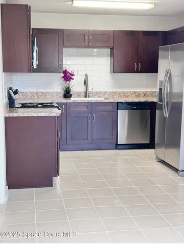 a kitchen with granite countertop a stove a sink and a microwave