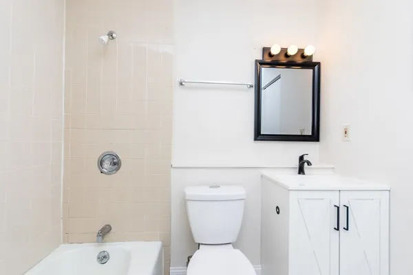 a bathroom with a toilet sink and mirror