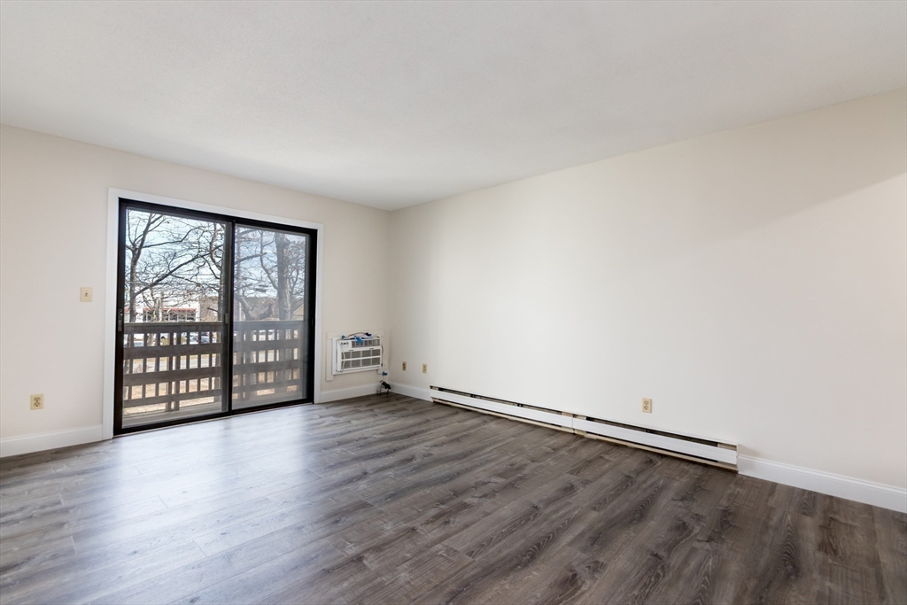 800 Bearses Way, Unit 3NE Hyannis, MA 02601 - Photo 4 of 20 an empty room with wooden floor and windows