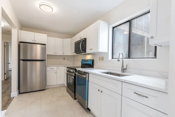 a kitchen with a refrigerator sink and cabinets