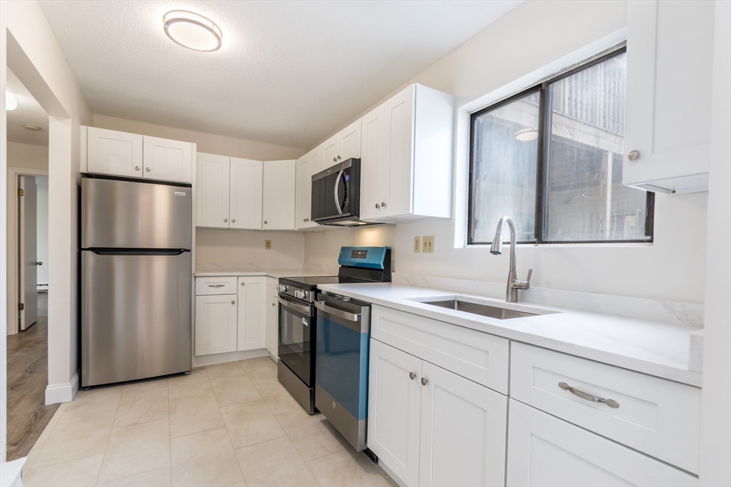 800 Bearses Way, Unit 3NE Hyannis, MA 02601 - Photo 6 of 20 a kitchen with a refrigerator sink and cabinets