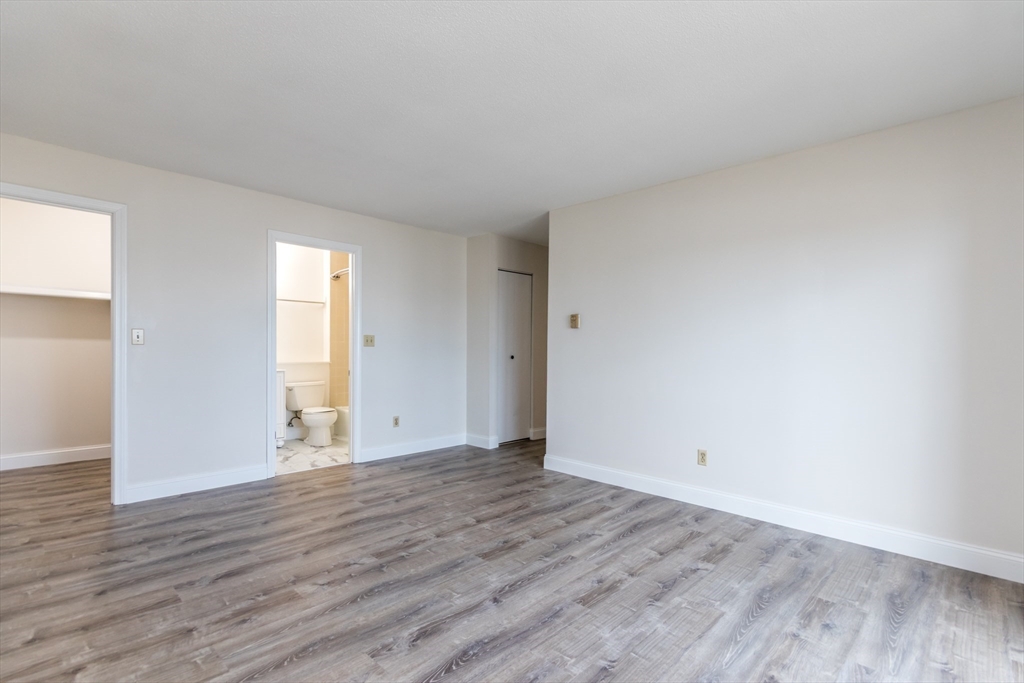 800 Bearses Way, Unit 3NE Hyannis, MA 02601 - Photo 8 of 20 a view of an empty room with wooden floor and a window