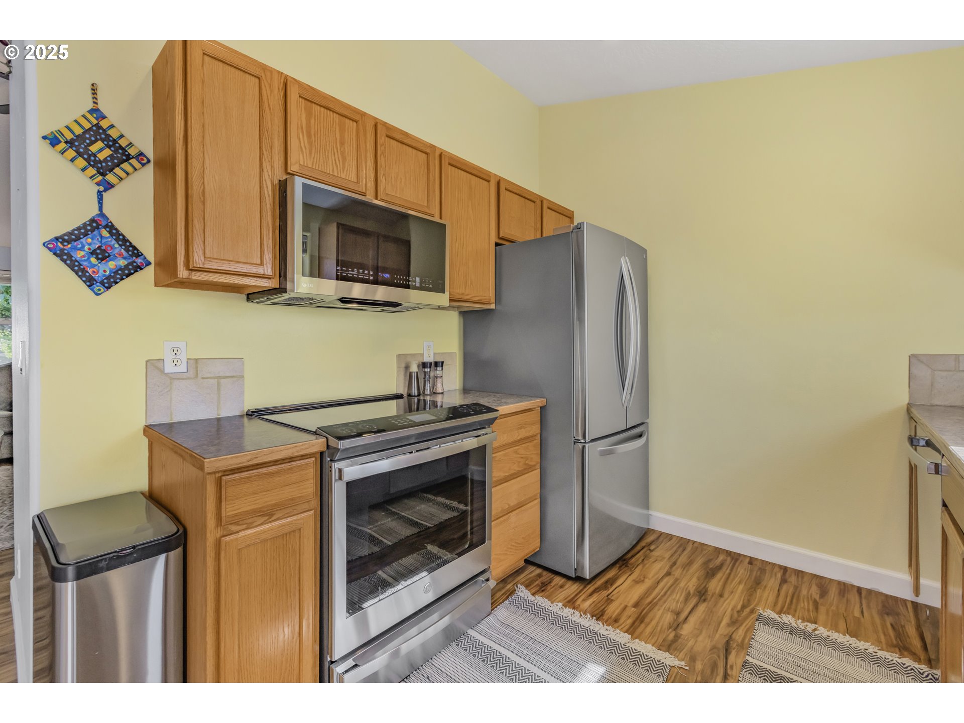 1580 South 60th Street Springfield, OR 97478 - Photo 16 of 36 a kitchen with stainless steel appliances a stove a microwave and wood floor