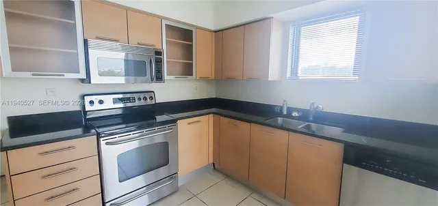 a kitchen with stainless steel appliances granite countertop a sink stove and cabinets