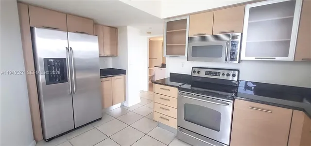 a kitchen with stainless steel appliances granite countertop a refrigerator and a stove
