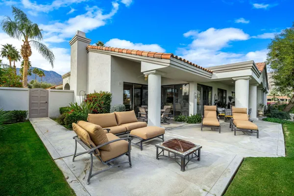 a view of a patio with couches and a table and chairs with garden view