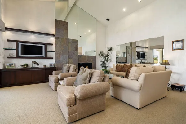 a living room with furniture fireplace and a large window