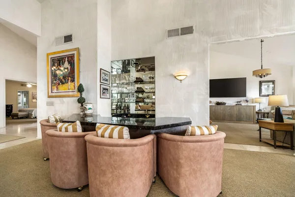 a dining room with furniture a chandelier and a flat screen tv