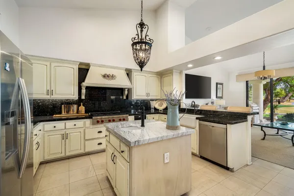 a kitchen with stainless steel appliances granite countertop a sink and white cabinets