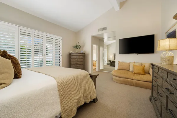 a spacious bedroom with a bed and a cabinets