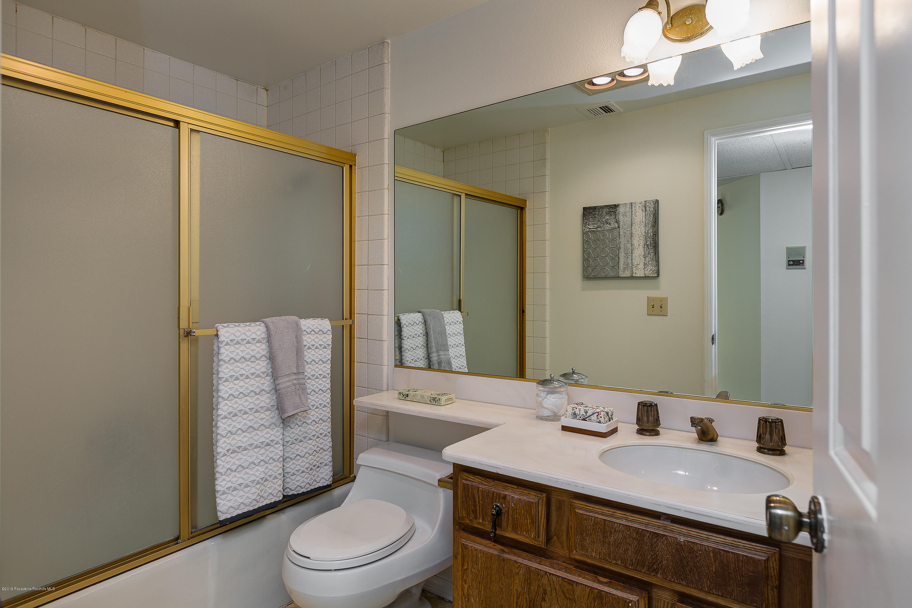 124 Monterey Road, Unit 218 South Pasadena, CA 91030 - Photo 16 of 20 a bathroom with a granite countertop sink toilet a mirror and shower