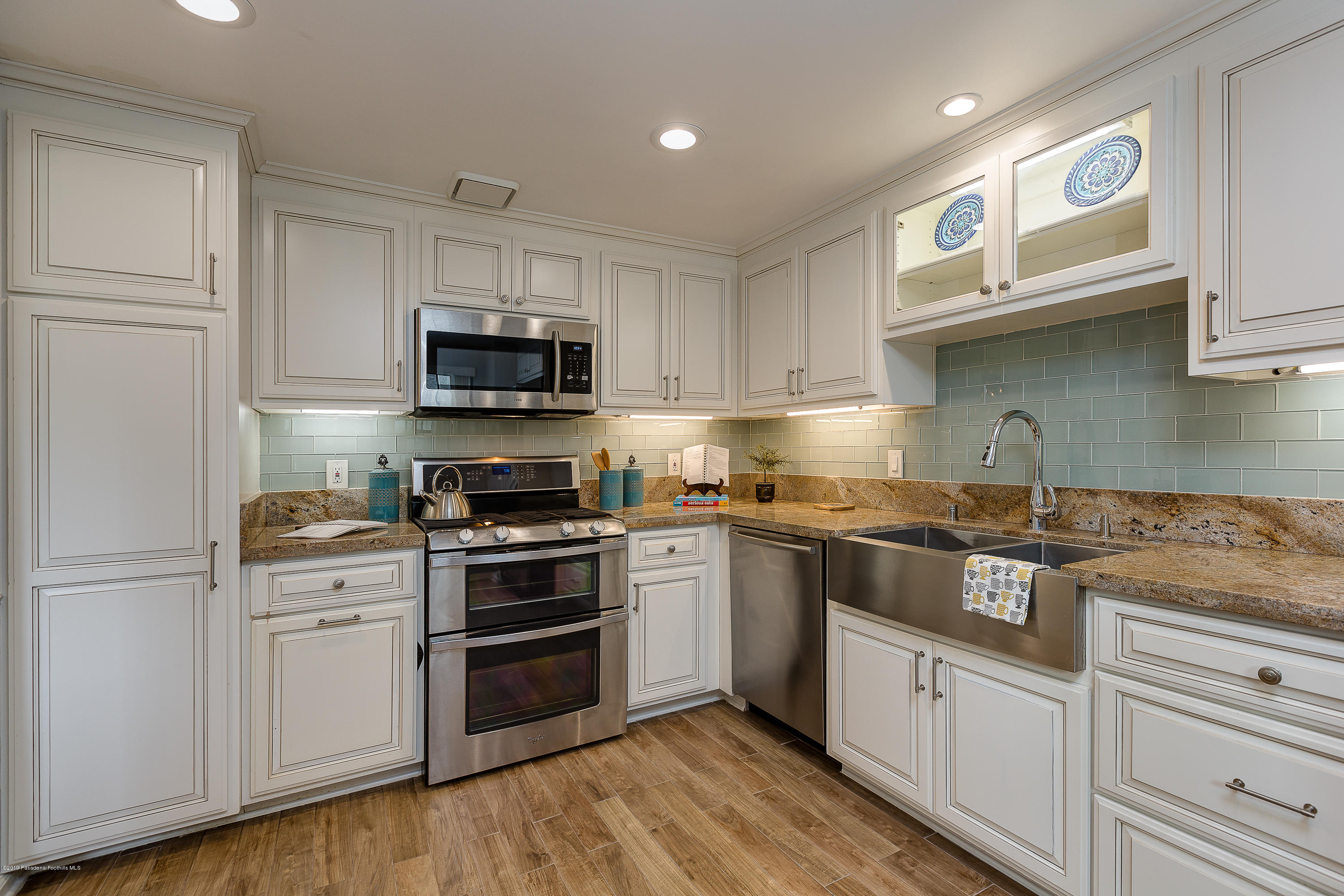 124 Monterey Road, Unit 218 South Pasadena, CA 91030 - Photo 3 of 20 a kitchen with granite countertop white cabinets and stainless steel appliances