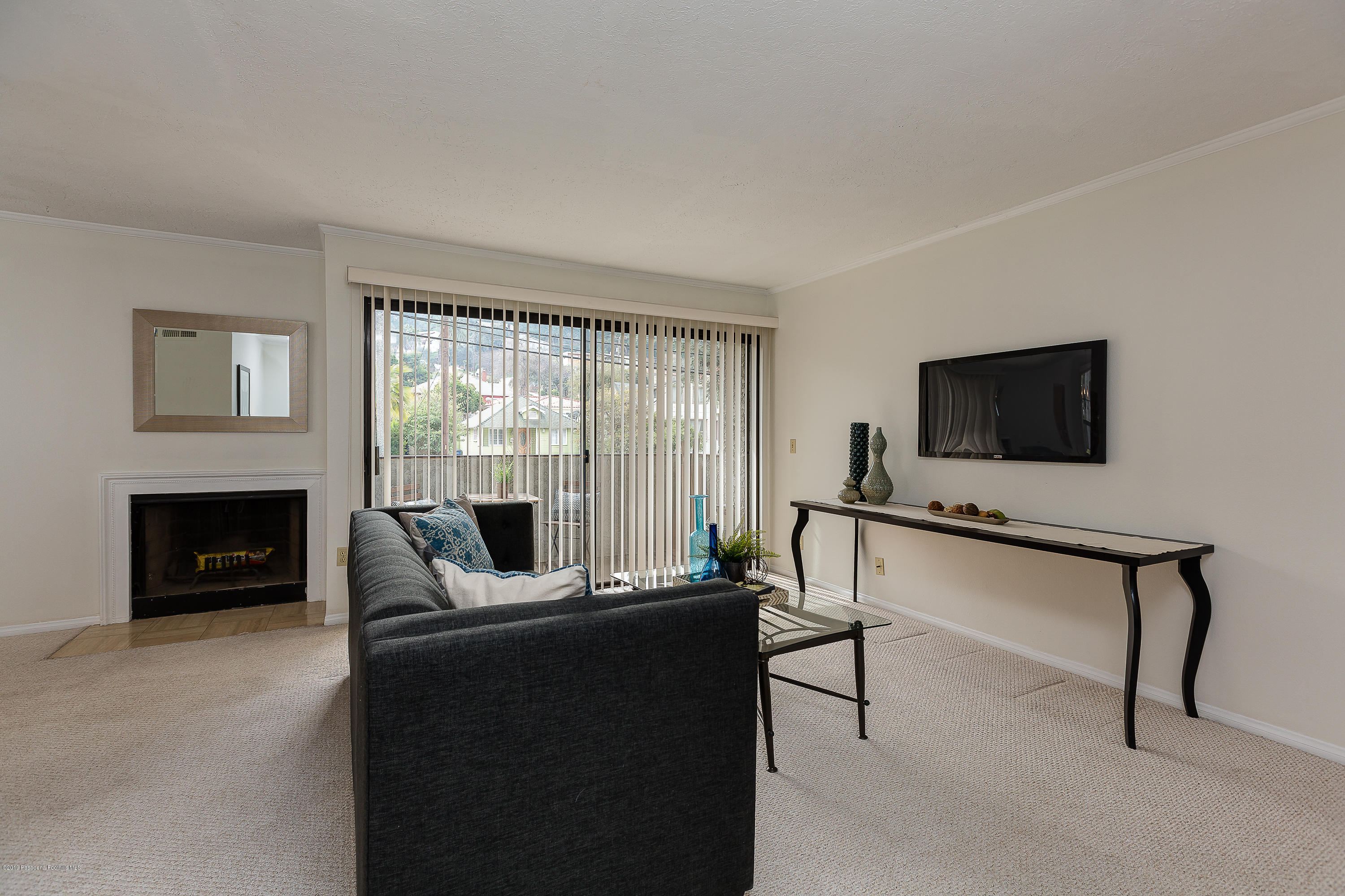 124 Monterey Road, Unit 218 South Pasadena, CA 91030 - Photo 8 of 20 a living room with furniture a fireplace and a flat screen tv