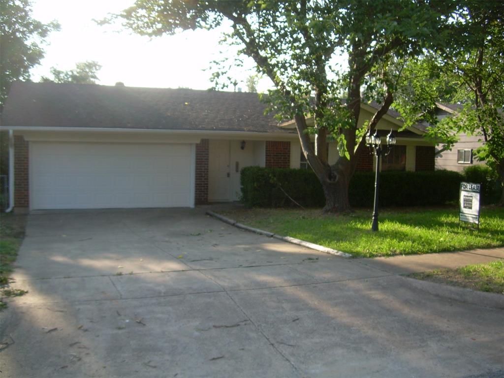 a view of a house with a yard and large tree