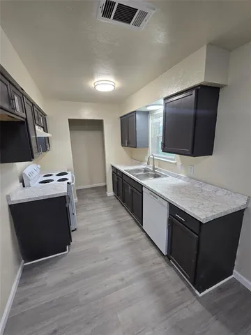 a large kitchen with stainless steel appliances granite countertop a stove a sink and a microwave