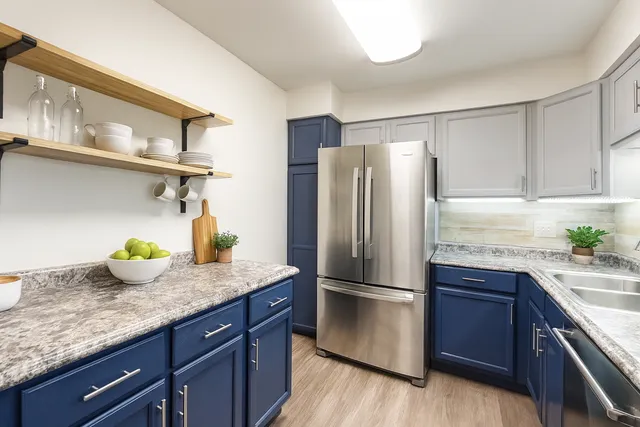 a kitchen with granite countertop kitchen island stainless steel appliances a refrigerator and a sink