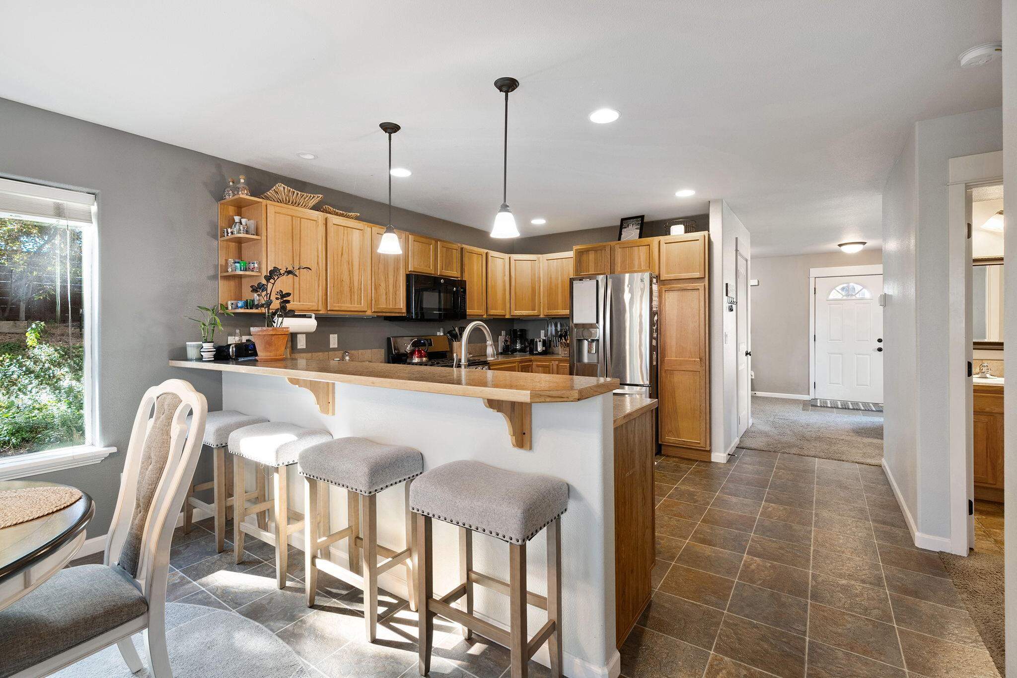 62906 Bilyeu Way Bend, OR 97701 - Photo 11 of 100 a kitchen with stainless steel appliances kitchen island granite countertop a refrigerator a oven a sink a dining table and chairs with wooden floor