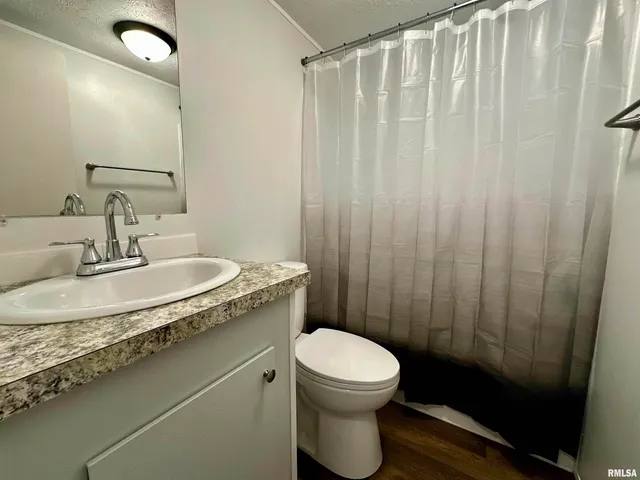 a bathroom with a granite countertop sink toilet and a mirror