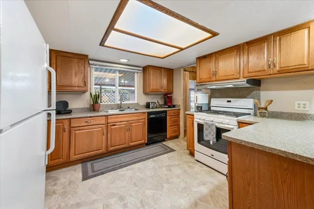 a kitchen with a sink stove top oven and refrigerator