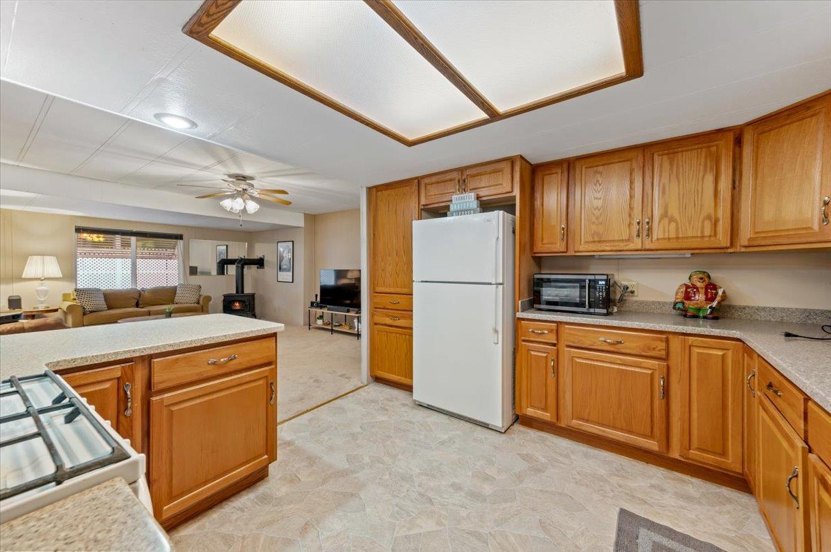 27 Primrose Lane Grass Valley, CA 95945 - Photo 14 of 44 a kitchen with refrigerator a sink a stove and cabinets