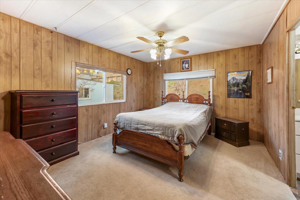 27 Primrose Lane Grass Valley, CA 95945 - Photo 15 of 44 a bedroom with a bed and a chandelier