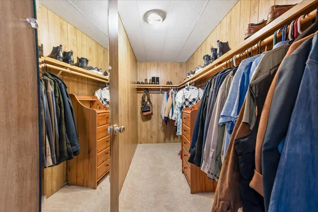 a view of walk in closet with clothes and shoes