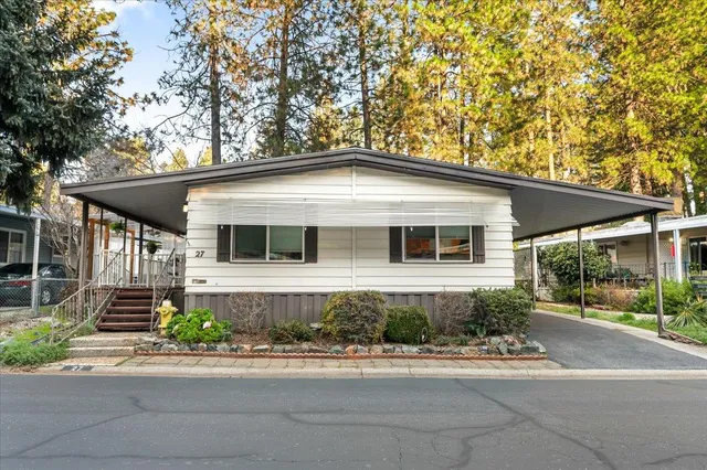 a front view of a house with a yard and potted plants
