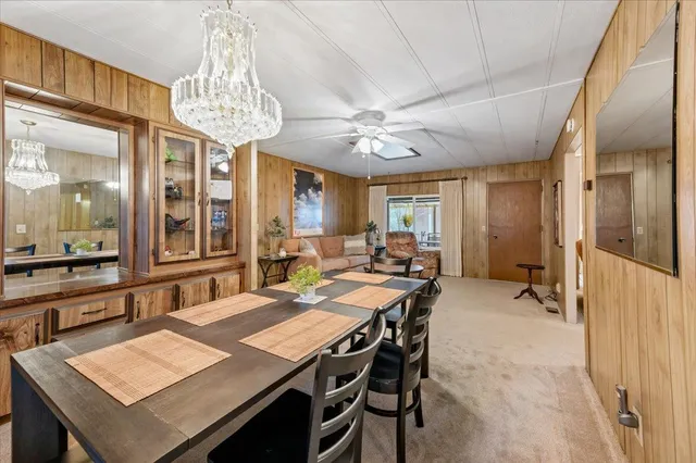 a view of a dining room with furniture a chandelier and window