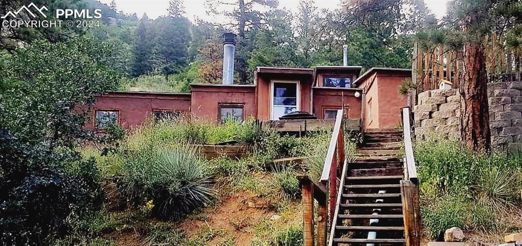 a view of a house with backyard and trees