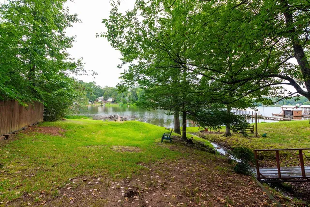 a large yard with lots of green space and house in the back
