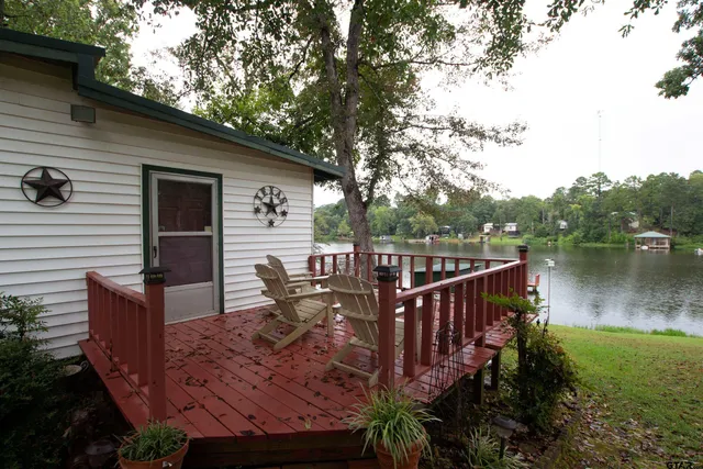 a balcony with wooden floor table and chairs