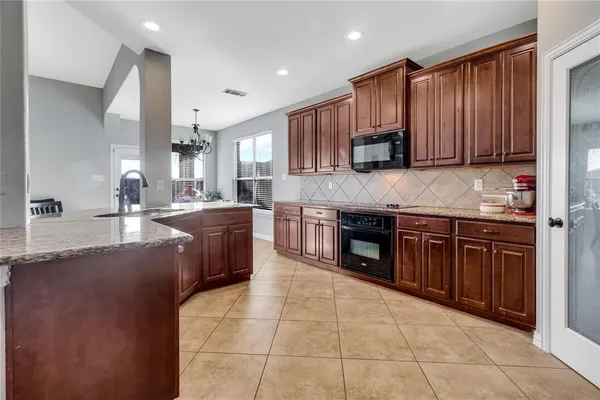 a kitchen with stainless steel appliances granite countertop wooden cabinets a sink and a stove