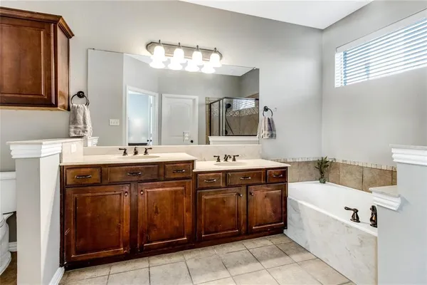 a bed sitting in a spacious bedroom next to a window