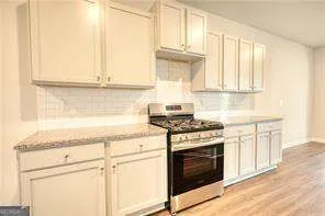a kitchen with granite countertop white cabinets and white appliances