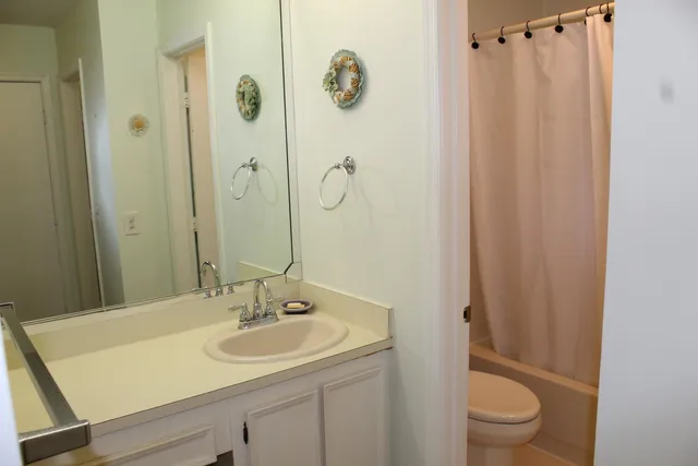 a bathroom with a granite countertop sink toilet and shower