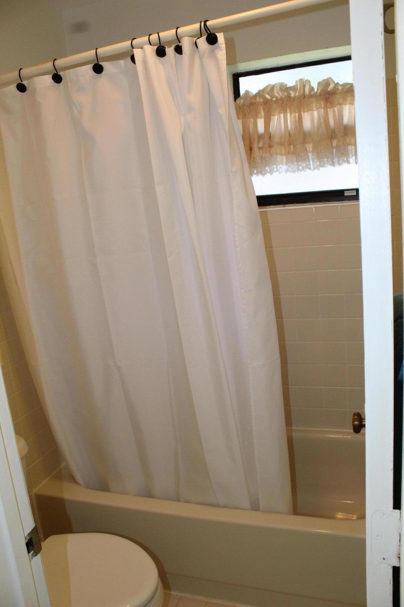 9825 Bischofia Tree Way, Unit B Boynton Beach, FL 33436 - Photo 10 of 12 a bathroom with a shower and a toilet