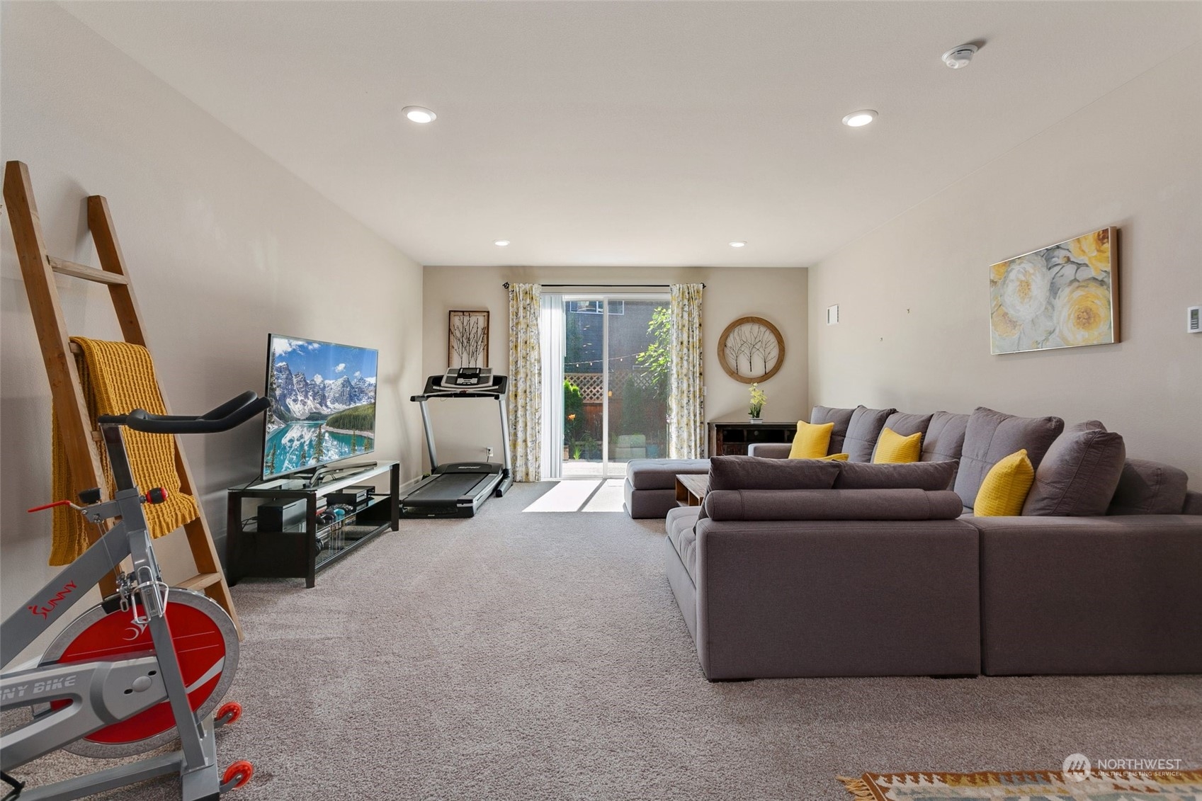 15931 Meridian Avenue South Bothell, WA 98012 - Photo 29 of 40 a living room with furniture a flat screen tv and a gym equipment