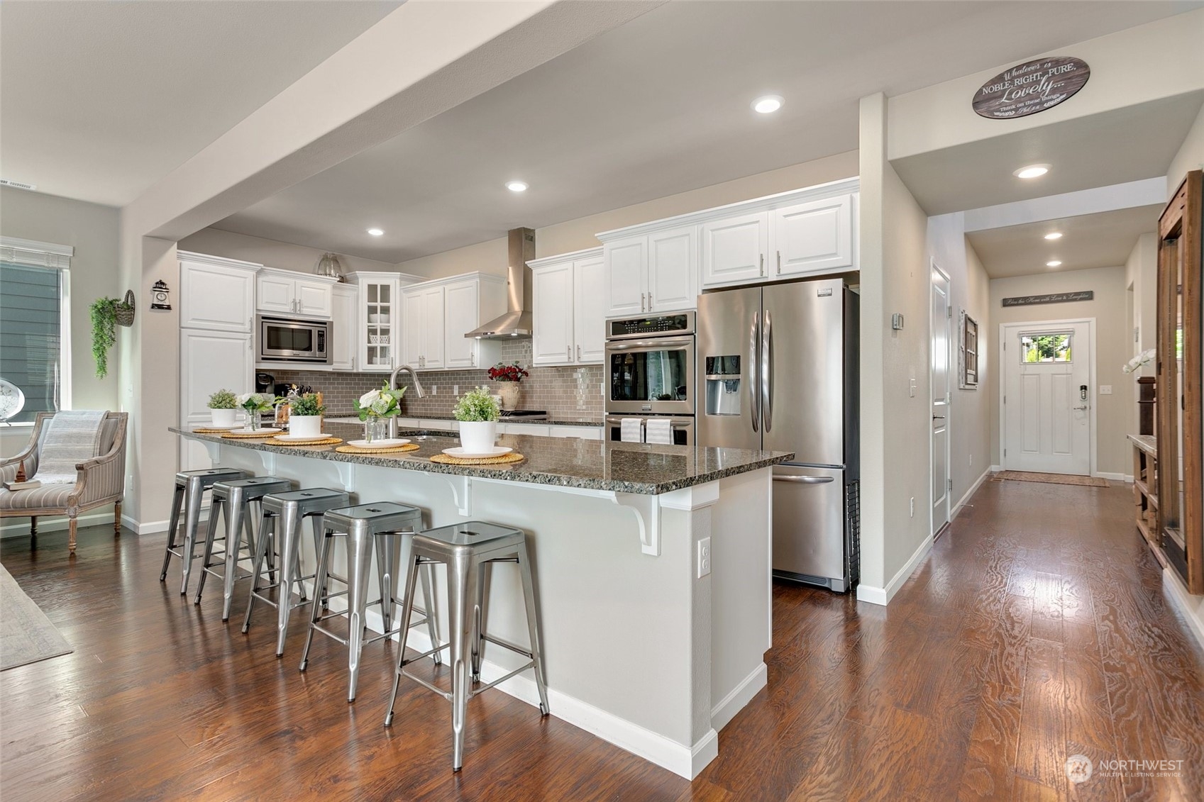 15931 Meridian Avenue South Bothell, WA 98012 - Photo 4 of 40 a kitchen with stainless steel appliances granite countertop a refrigerator a oven a sink a dining table and chairs with wooden floor