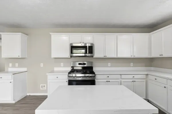 a kitchen with white cabinets and stainless steel appliances