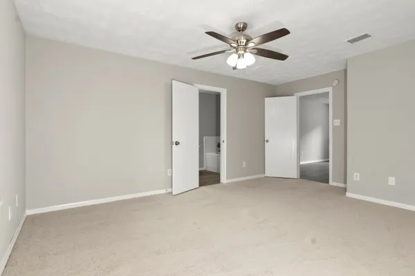 an empty room with chandelier fan