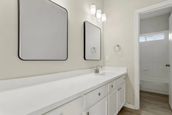 a bathroom with a double vanity sink and a mirror