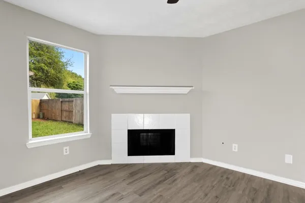 a view of an empty room with a window and fireplace