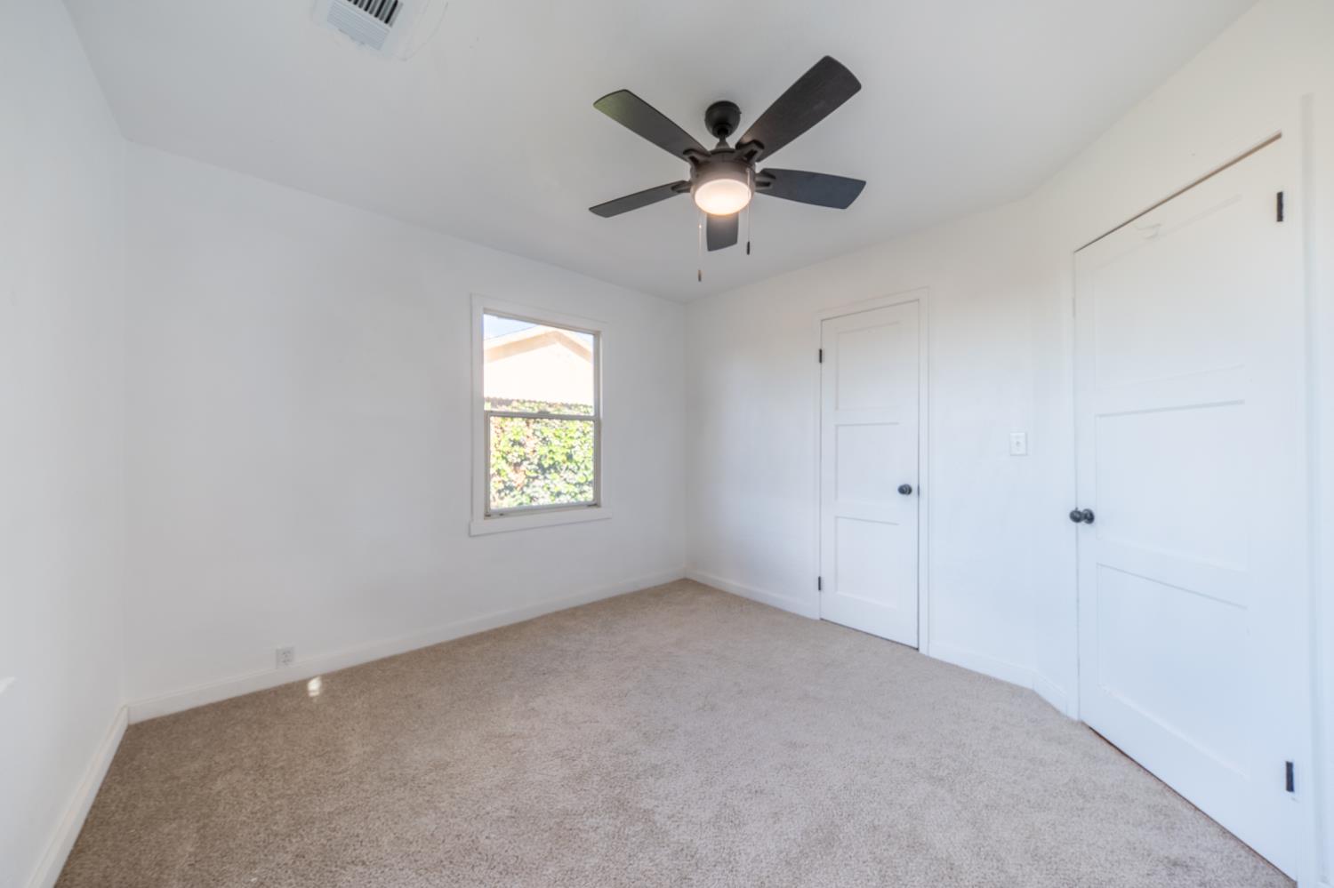 2790 Boles Street Madera, CA 93637 - Photo 13 of 19 an empty room with a window and a fan