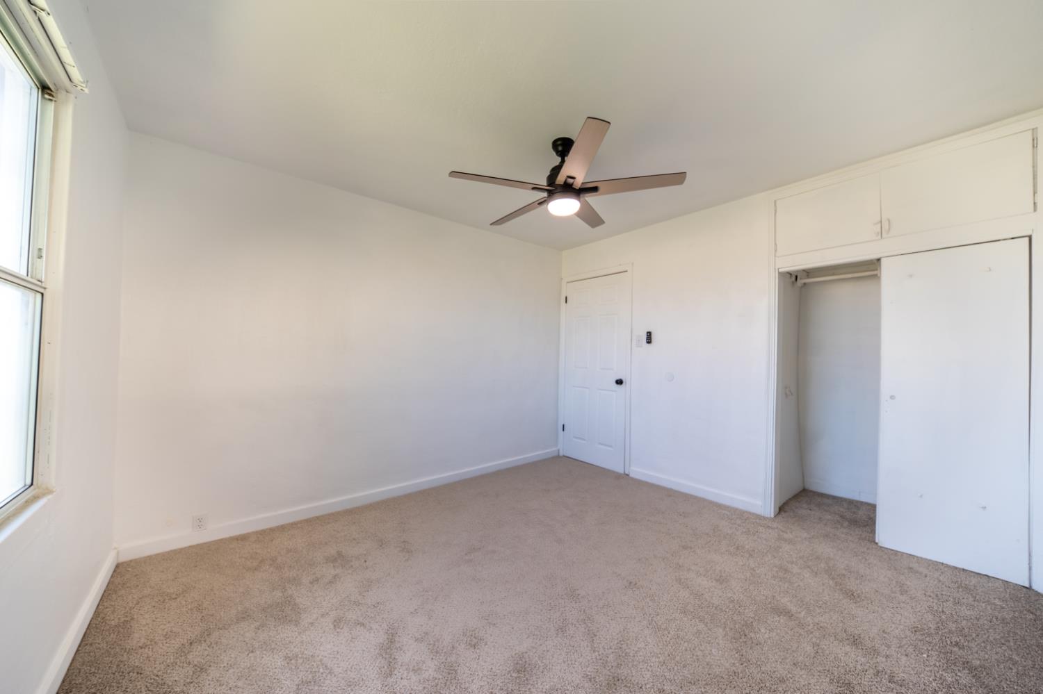 2790 Boles Street Madera, CA 93637 - Photo 16 of 19 an empty room with a ceiling fan and a window