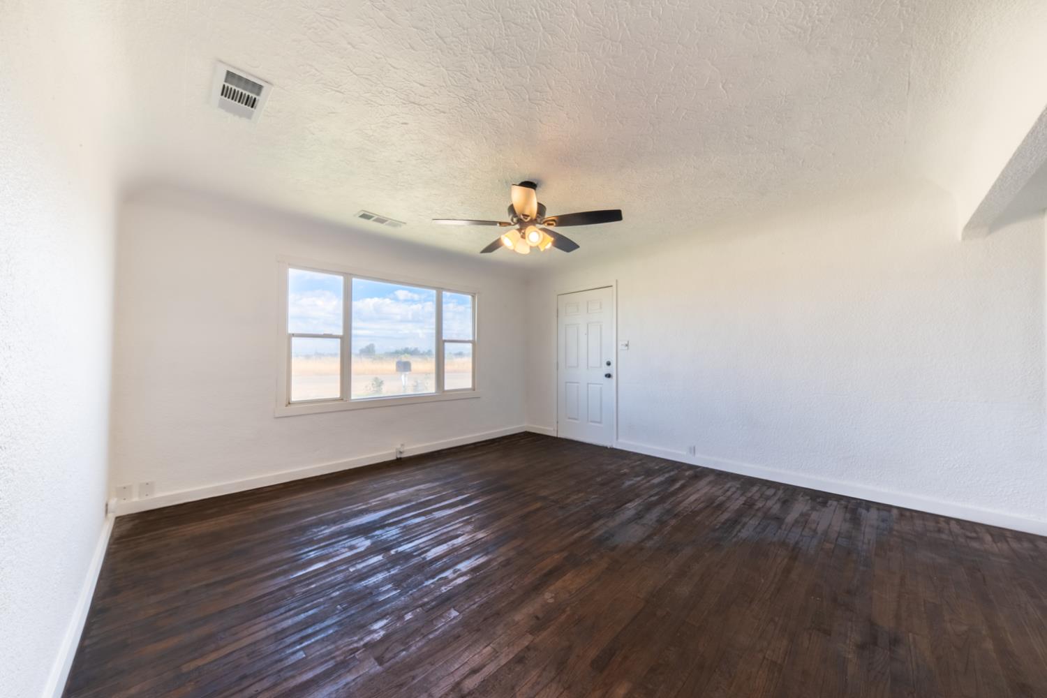 2790 Boles Street Madera, CA 93637 - Photo 6 of 19 wooden floor in an empty room with a window